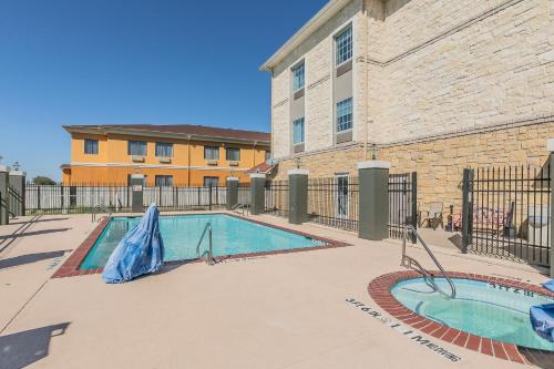 a swimming pool in front of a building at La Quinta by Wyndham Granbury in Granbury