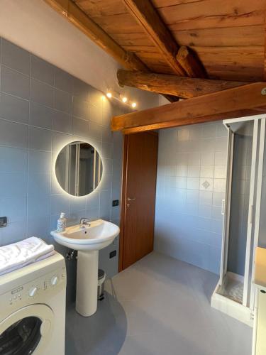 een badkamer met een wastafel en een wasmachine bij BINARIO 63 Este in Este