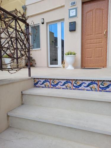 a front door of a house with a mosaic tile staircase at Casa Alecci 1820 in Modica