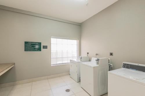 a white laundry room with a washer and dryer at La Quinta by Wyndham Granbury in Granbury
