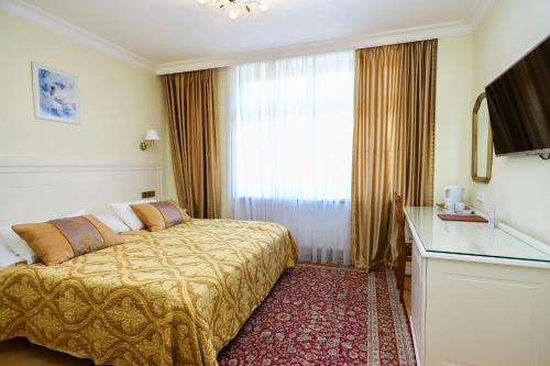 a hotel room with a bed and a window at Zlatý Sloup in Karlovy Vary