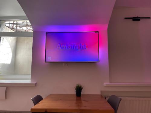 a television hanging on a wall with a table at Modern guest house in city center I Room 1 in Vilnius