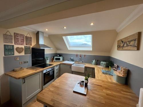 a kitchen with a wooden table and a window at Taigh Mara(Marine House) 2 bed Apartment in Fort William