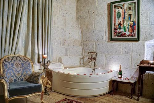 ein Badezimmer mit einer Badewanne und einem Stuhl in der Unterkunft Mahperi Cappadocia Cave in Nevşehir