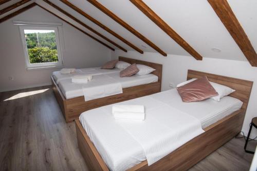 two beds in a room with a window at Villa Tia Čitluk in Čitluk