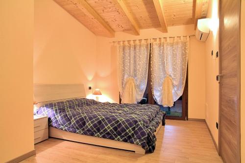 a bedroom with a bed and a window with curtains at Agriturismo Il Melograno in Tessera