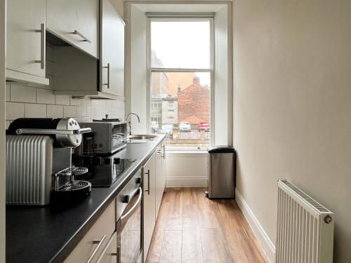 a kitchen with a counter and a window in it at Large Blythswood Residence in Glasgow