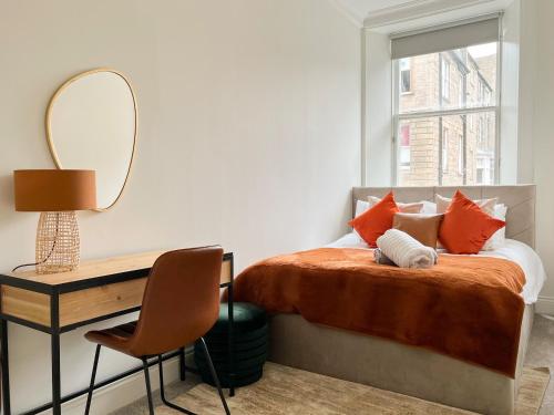 a bedroom with a bed with a mirror and a desk at Large Blythswood Residence in Glasgow