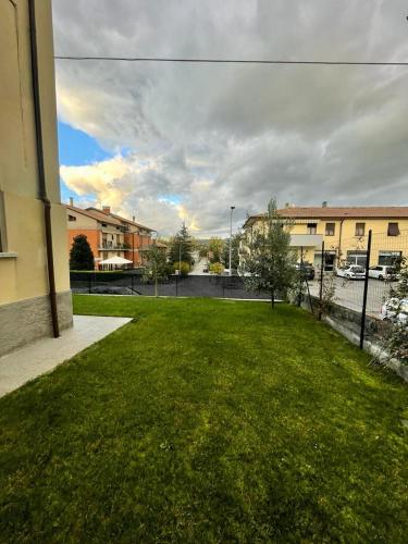 a grassy yard with buildings and a fence at B&B Camelia in Città di Castello