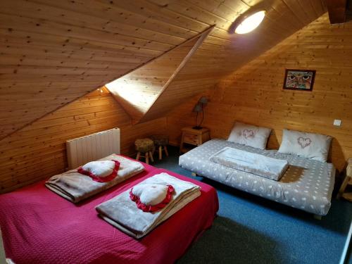 a attic bedroom with two beds in a attic at Location à la Montagne avec piscine été / hiver vg23 in Saint-François-Longchamp