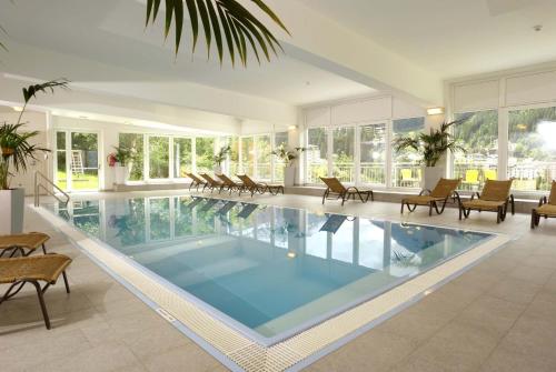 ein großer Pool in einem Haus mit Stühlen in der Unterkunft Design Apartments mit Pool und fantastischem Ausblick in Bad Gastein