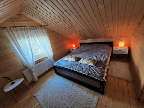 een uitzicht op een bed in een houten kamer bij Domek Mazury całoroczny letniskowy Dom Apartament na Mazurach in Ryn