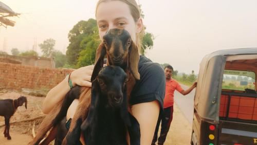 a woman holding a dog with its face on at The Mountain View Home Stay in Khajurāho