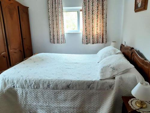 1 dormitorio con 1 cama con sábanas blancas y ventana en La Casuca de La Franca, en La Franca