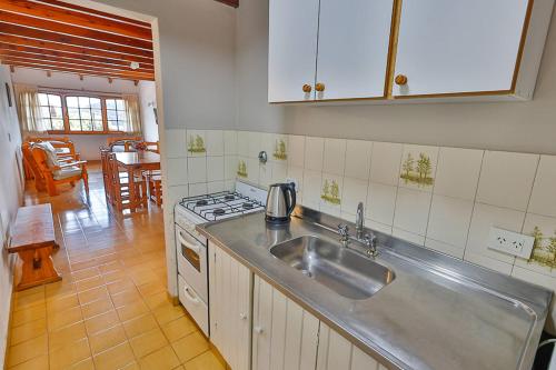 a kitchen with a sink and a stove at LA PONDEROSA Apart Hotel in San Carlos de Bariloche