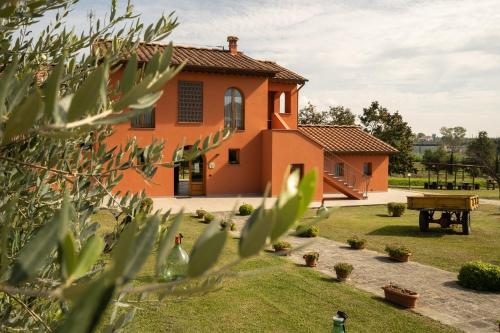 una casa naranja con una mesa de picnic en un patio en Incanto Toscano, en Larciano