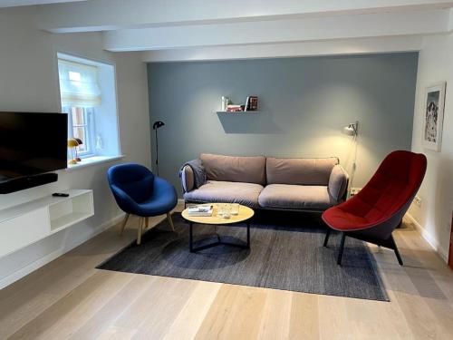 a living room with a couch and two chairs at Wöda in Nieblum