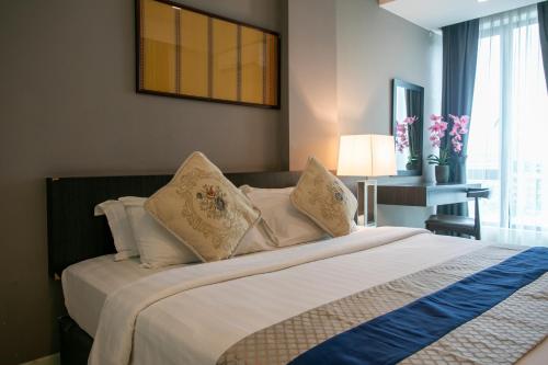 a bedroom with a bed with white sheets and pillows at Sky Hotel in Kota Kinabalu
