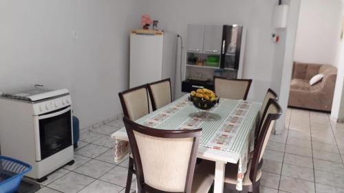 cocina con mesa, sillas y nevera en Nosso Lar casa inteira, completa e independente en Barra do Garças