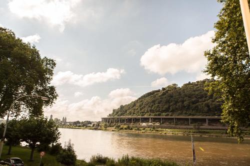 a view of a river with trees and a train at Hotel Leyscher Hof in Leutesdorf