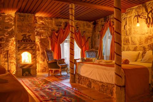 a bedroom with a bed and a fireplace at Mahperi Cappadocia Cave in Nevsehir