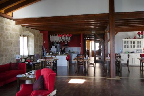 a living room with tables and chairs and a kitchen at Casa Rural Osante in Labastida