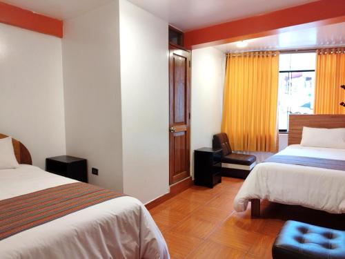 a hotel room with two beds and a window at Amakonkay Machupicchu in Machu Picchu