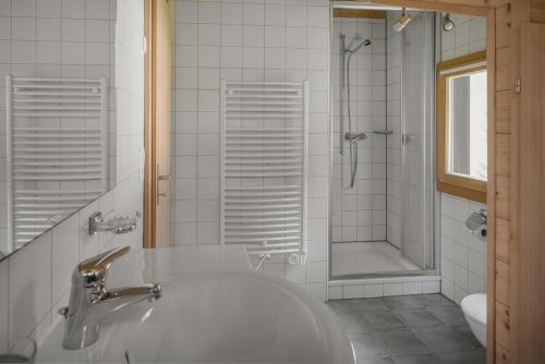 a white bathroom with a sink and a shower at Tschiffra OG in Bettmeralp