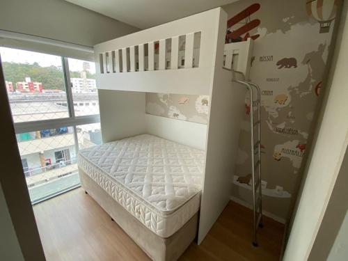 um quarto para crianças com um beliche e uma janela em Apto luxo e conforto suíte mais dormitório com churrasqueira em Balneário Camboriú