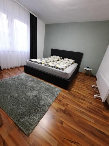 a bedroom with a bed and a wooden floor at apartman Magnolia in Sarajevo