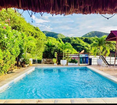 a swimming pool in a resort with mountains in the background at Casa Relax - Adults Only in Taganga