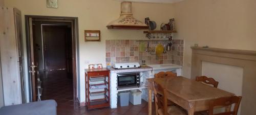 een keuken met een tafel en een fornuis top oven bij azienda agrituristica la torretta in Tocco da Casauria