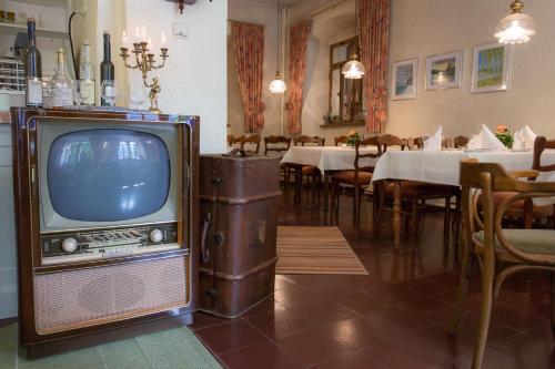 Leutesdorf的住宿－萊斯切霍夫酒店，餐厅里的一台旧电视,餐厅里设有饭厅