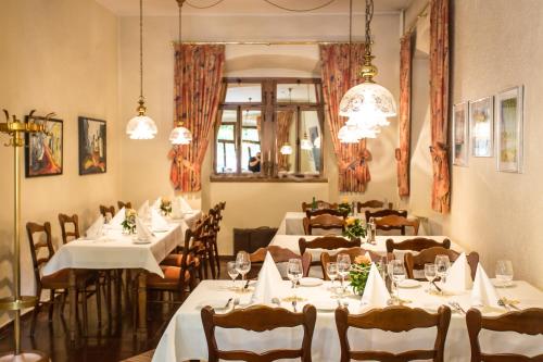 a restaurant with white tables and chairs and chandeliers at Hotel Leyscher Hof in Leutesdorf