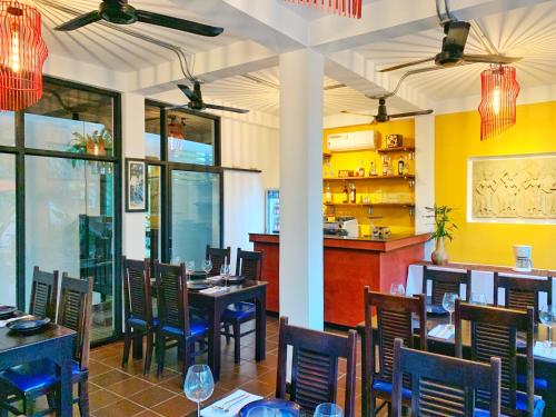 a restaurant with tables and chairs and a bar at The Bliss Angkor in Siem Reap