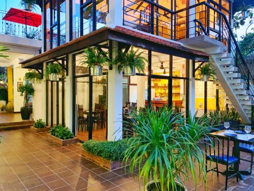 a building with a staircase and tables and plants at The Bliss Angkor in Siem Reap