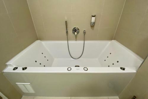 a white bath tub with a shower in a bathroom at ALPEN-PANORAMA SUITE - Einzigartige Privatsuite hoch über München, 12tes OG, Alpenblick, Loggia, Whirlpool, 15 Minuten zum Zentrum, Ruhe und Erholung in der Stadt München für privat und geschäftlich Reisende in Munich
