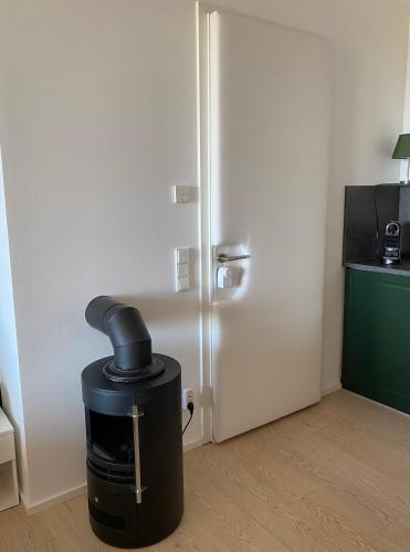 a heater in a room next to a refrigerator at ALPEN-PANORAMA SUITE - Einzigartige Privatsuite hoch über München, 12tes OG, Alpenblick, Loggia, Whirlpool, 15 Minuten zum Zentrum, Ruhe und Erholung in der Stadt München für privat und geschäftlich Reisende in Munich