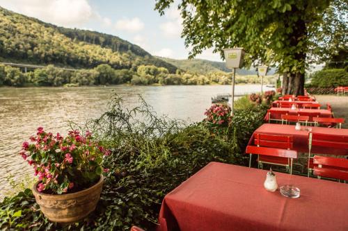 a row of tables and chairs next to a river at Hotel Leyscher Hof in Leutesdorf