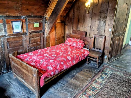 een bed met een rood dekbed in een kamer bij House of secrets in Morlaix