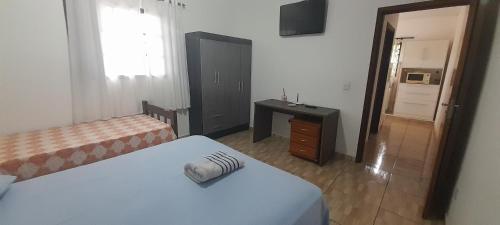 a bedroom with two beds and a desk and a sink at Suits - Canto do sabia in Brotas