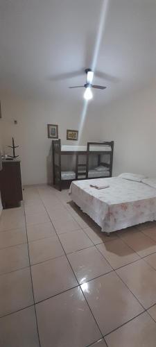 a bedroom with two beds and a ceiling fan at Suits - Canto do sabia in Brotas