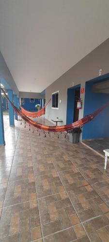 a large room with a large red hammock in it at Suits - Canto do sabia in Brotas