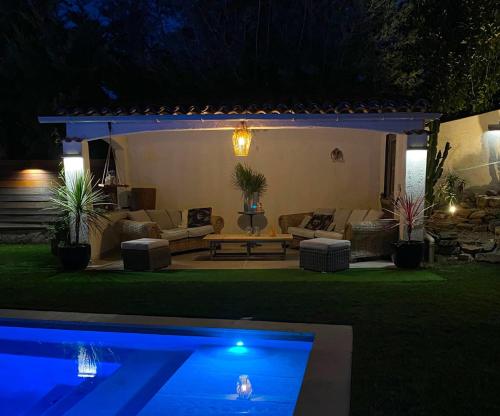 a backyard at night with a couch and a pool at La Dolce Villa 11 persones Private Pool beautiful Landscaped Garden in Mandelieu-La Napoule