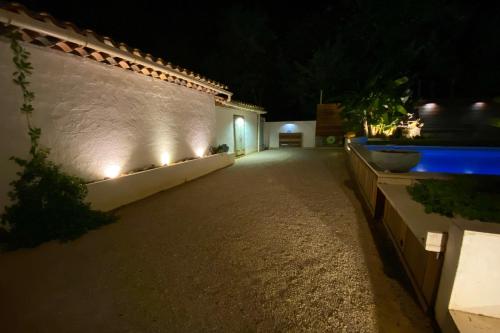 an empty alley at night with lights on a wall at La Dolce Villa 11 persones Private Pool beautiful Landscaped Garden in Mandelieu-La Napoule