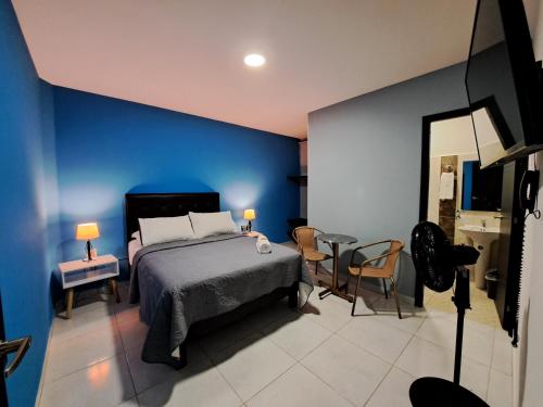 1 dormitorio con cama y pared azul en Hotel 9-25 en Pereira