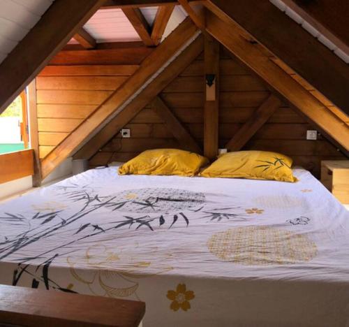 een bed met 2 kussens op een zolder bij La tiny de titanse avec piscine in Cadet