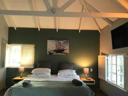 um quarto com uma cama grande e 2 janelas em Aluve Guesthouse em Joanesburgo
