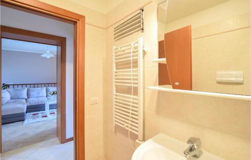 baño con lavabo, aseo y sofá en 2 Bedroom Stunning Apartment In Aprilia Marittima, en Aprilia Marittima