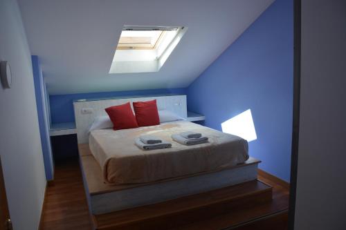 een blauwe slaapkamer met een bed met rode kussens bij Lagunas Ruidera 15 Agua y Placer in Ruidera
